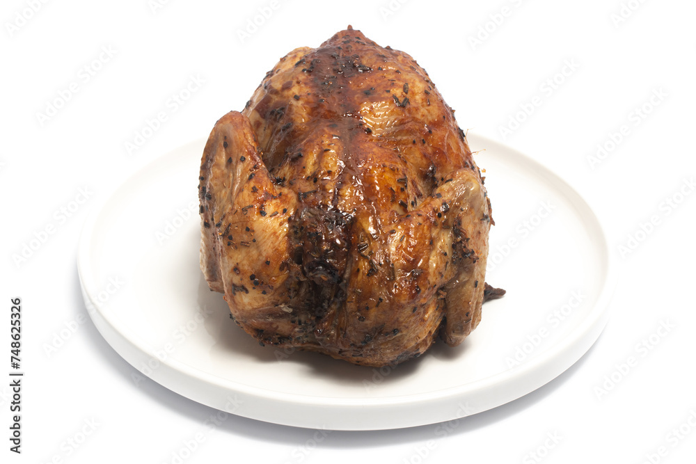 A whole delicious roasted chicken seasoned with herbs in a white plate isolated on white background clipping path A whole delicious roasted chicken seasoned with herbs in a white plate isolated on white background clipping path