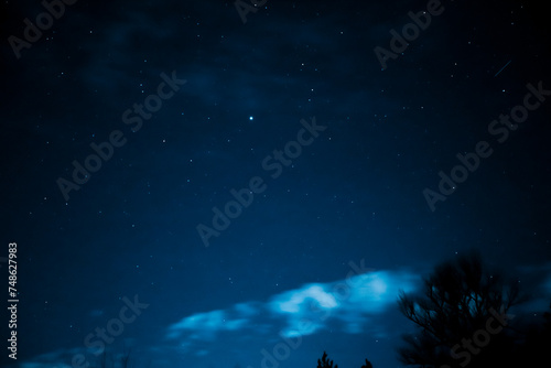 Fototapeta Naklejka Na Ścianę i Meble -  Stars in the night sky through the clouds. Beautiful starry night sky with clouds.