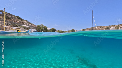 Underwater split photo of traditional fishing wooden boats in port of Iraklia island  small Cyclades  Greece