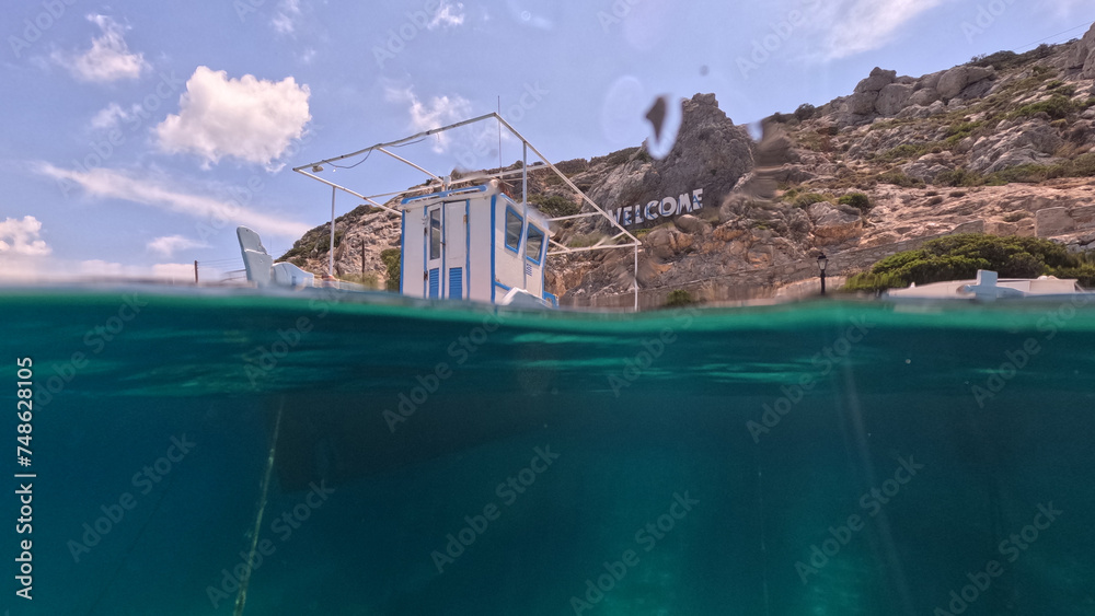 Underwater split photo of traditional fishing wooden boats in port of Iraklia island, small Cyclades, Greece