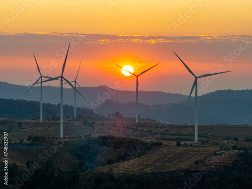 Aerial view from drone silhouette wind turbines farm at sunset