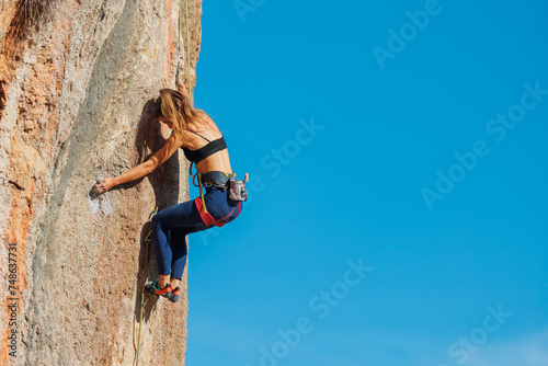 rock climber girl. rock climber girl climbs an overhanging rock.