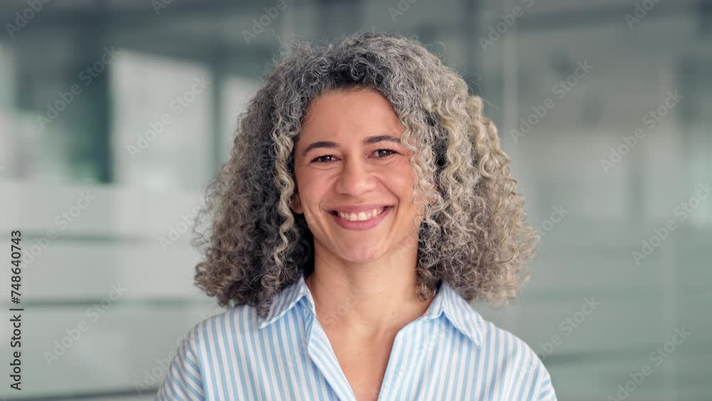 Happy middle aged professional business woman standing in office, portrait. Smiling mature senior female corporate leader, confident lady executive manager looking at camera, close up.
