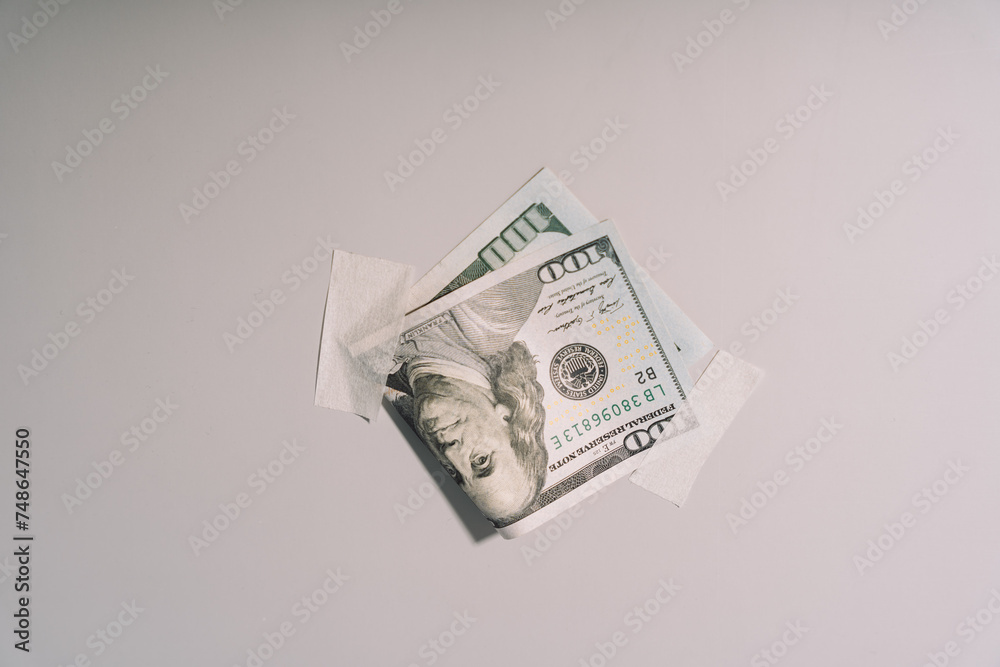 One hundred dollar bill glued to paper tape on a light wall. High quality photo One hundred dollar bill glued to paper tape on a light wall. High quality photo