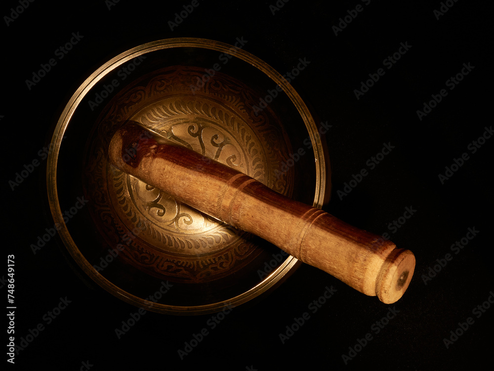 Fototapeta premium A cenital view of a Tibetan singing bowl in a black background 