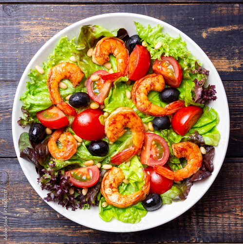 Salad with shrimps, tomatoes, olives and nuts. Healthy eating.