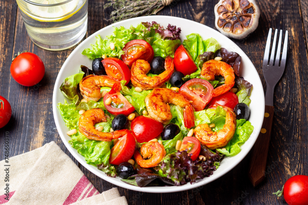 Salad with shrimps, tomatoes, olives and nuts. Healthy eating.