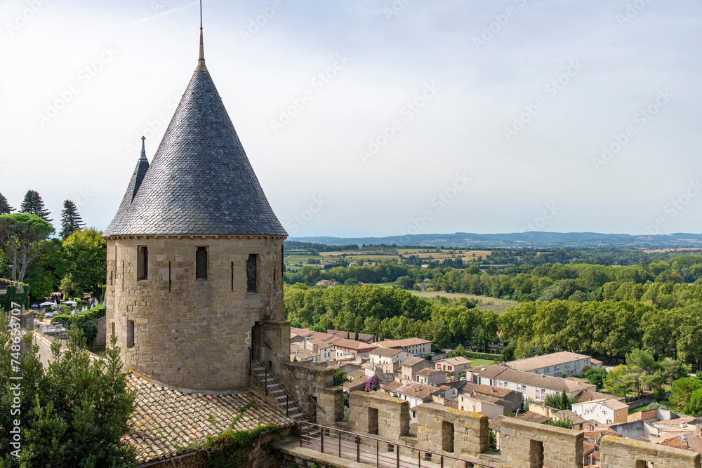 View over fortified wall with battlement and tower towards French landscape of the city of Carcassonne, a medieval fortress from Gallo-Roman period and part of UNESCO list of World Heritage Sites View over fortified wall with battlement and tower towards French landscape of the city of Carcassonne, a medieval fortress from Gallo-Roman period and part of UNESCO list of World Heritage Sites