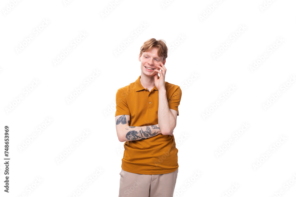 young fashionable student man with short red hair dressed in a yellow t-shirt is actively gesturing young fashionable student man with short red hair dressed in a yellow t-shirt is actively gesturing