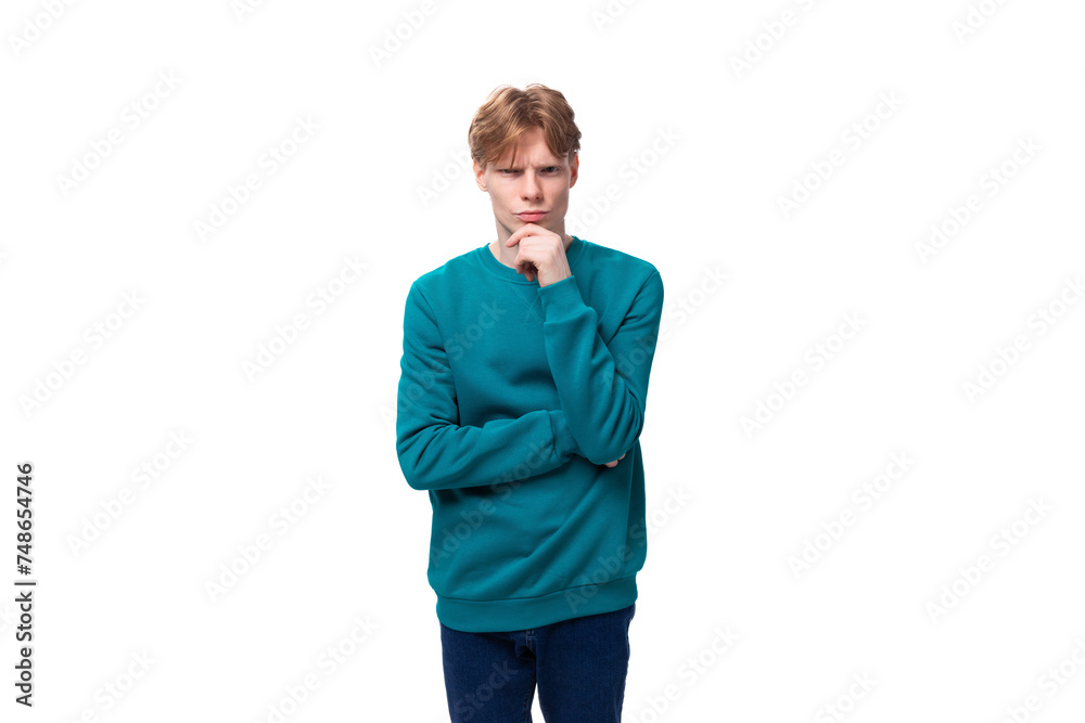 smart caucasian young red-haired guy dressed in a blue pullover on a white background with copy space smart caucasian young red-haired guy dressed in a blue pullover on a white background with copy space