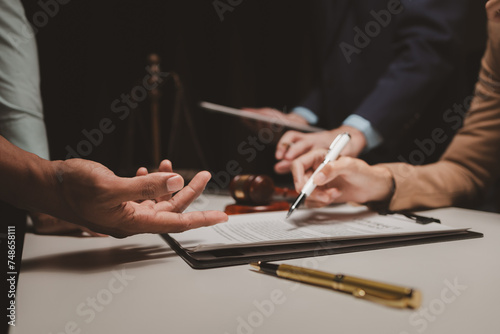 A group of lawyers is discussing contract documents that must be presented to a client, Lawyers brainstorm to revise important documents that must be submitted to the Supreme Court. photo