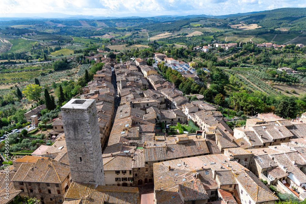 High angle panoramic view over San Gimignano, Italy with view on the tower Torre dei Cugnanesi  and typical Tuscan landscape in the background