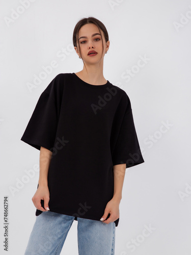 mockup of a black loose-fitting t-shirt on a young beautiful girl