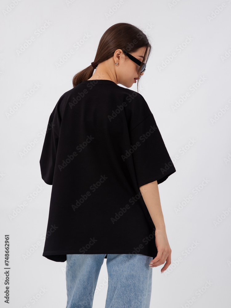 Fototapeta premium mockup of a black loose-fitting t-shirt on a young beautiful girl