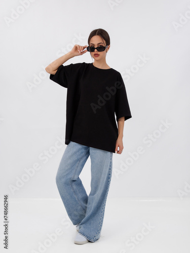 mockup of a black loose-fitting t-shirt on a young beautiful girl
