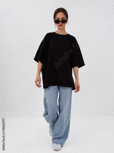 mockup of a black loose-fitting t-shirt on a young beautiful girl