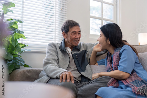 Happy mature husband and wife sit rest on comfortable sofa in living room enjoy talking, smiling elderly couple relax on couch at home chat speak laugh on leisure weekend photo