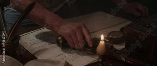 A sailor writes a letter sitting by the old table inside the sailing ship cabin