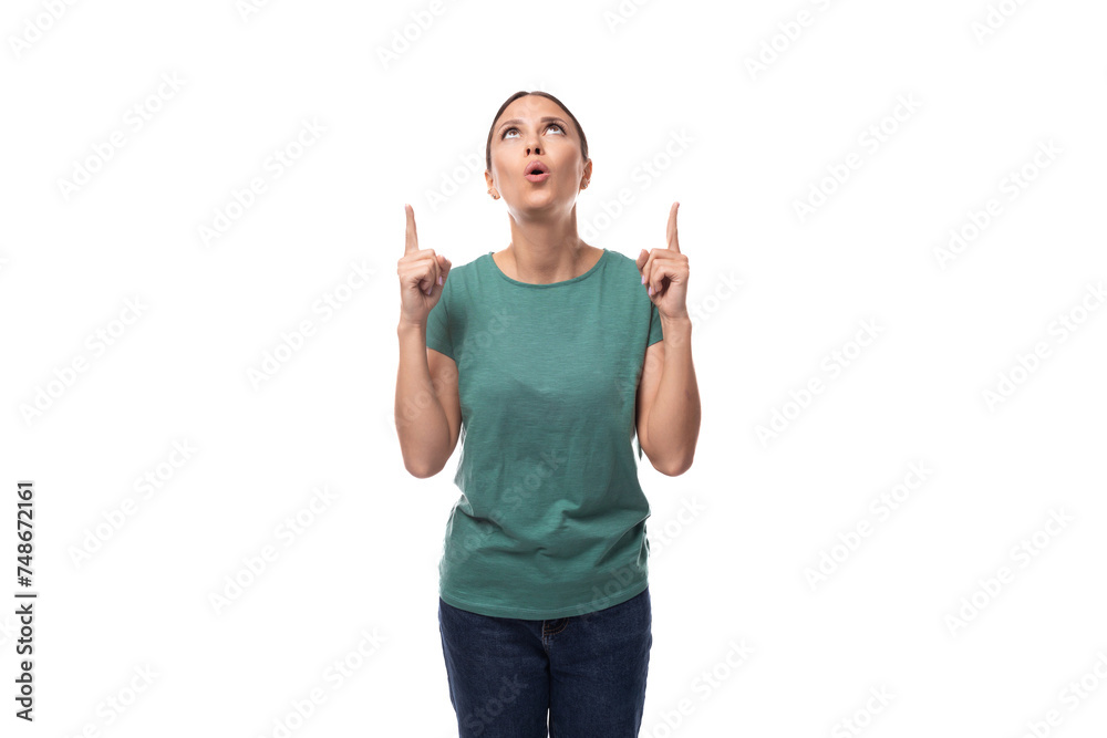 well-groomed young brunette woman dressed in a green t-shirt and jeans looks up in surprise well-groomed young brunette woman dressed in a green t-shirt and jeans looks up in surprise