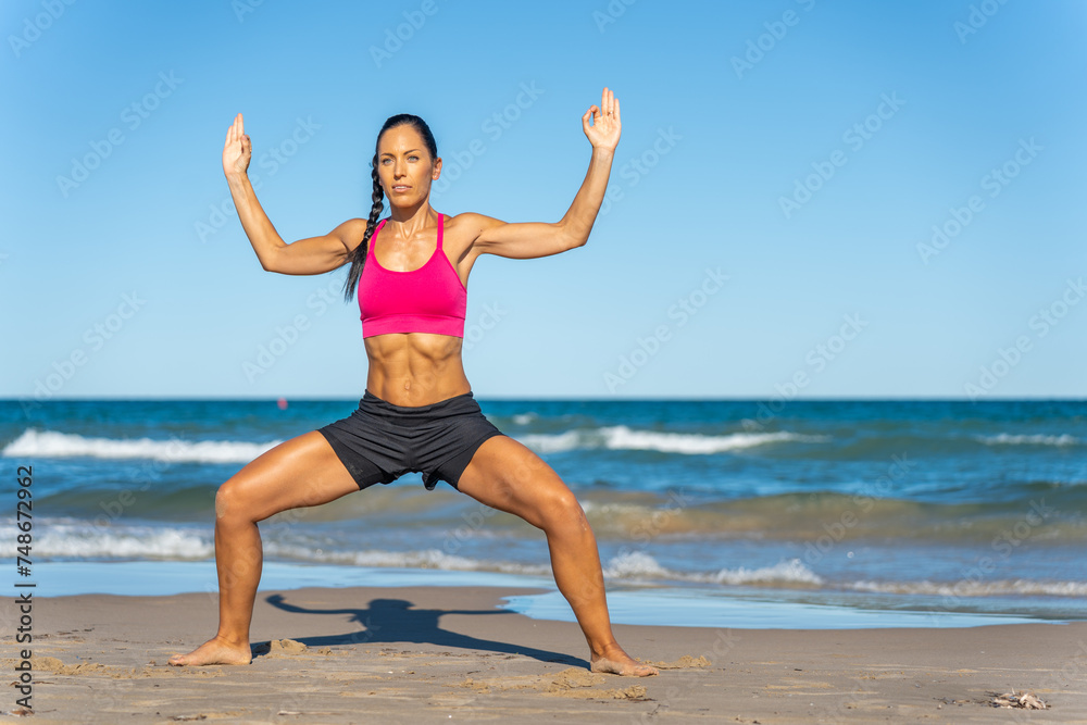 Middle aged woman exercising on the beach this summer Middle aged woman exercising on the beach this summer