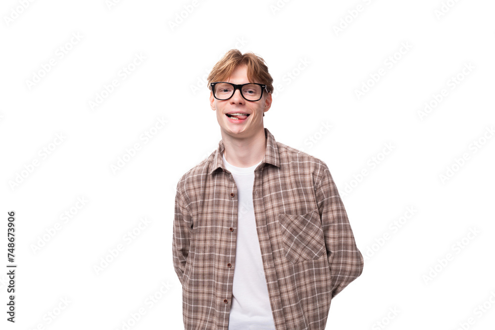 a young smiling man with red golden hair in glasses and a shirt stands alone on a white background a young smiling man with red golden hair in glasses and a shirt stands alone on a white background