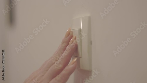 Close up shot of a woman hand turning light switch off