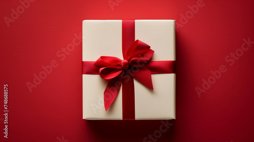 a white box with a red ribbon on a red background © junaid