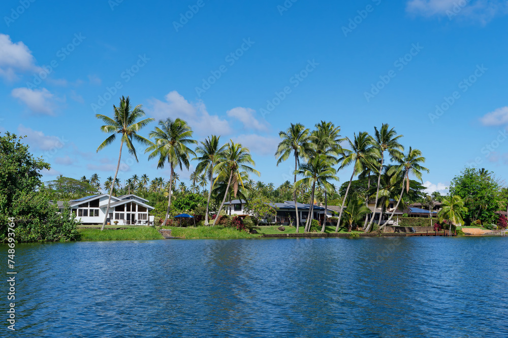 View from a tourist boat of houses on the bank of the Wailua River, Kauai Island, Hawaii