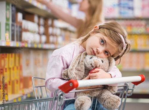 Cute child holding a plushie at the grocery store