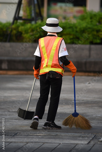 Frau kehrt die Strasse in Thailand