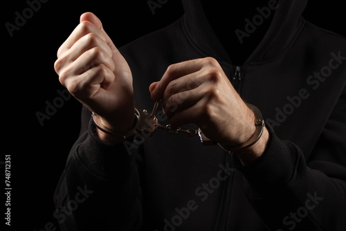 Close up of police staff hand Unlocking Handcuff on male accused hand by key, focus on key handcuff