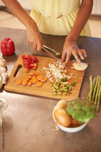 Hands, cooking and food with person in kitchen of home from above for health, diet and nutrition. Table, ingredients or recipe and chef chopping or cutting vegetables with knife closeup in apartment