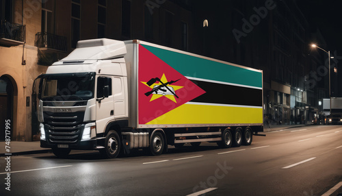 A truck with the national flag of Mozambique depicted carries goods to another country along the highway. Concept of export-import,transportation, national delivery of goods.