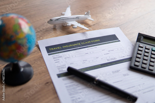 Selective focus image of travel insurance claim form on a wooden table. Travel, protection and insurance concept. photo