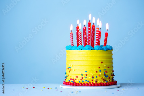 Brightly colored celebration birthday cake with red candles