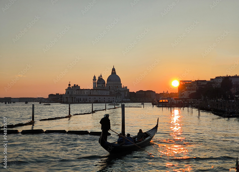 Gondola at sunset in Venice, with Basilica della Salute in the background