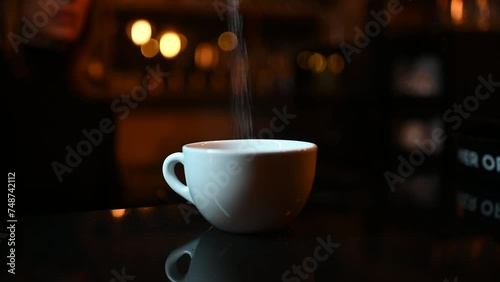 Putting sugar in coffee in the white cup