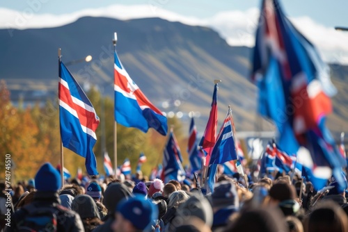A sea of Icelandic flags ripple in the wind as a crowd gathers to celebrate a national event, with the majestic mountains as a backdrop.