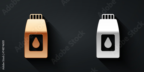 Gold and silver Canister for motor machine oil icon isolated on black background. Oil gallon. Oil change service and repair. Long shadow style. Vector