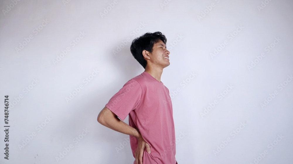 Asian man with a gesture holding his painful waist Asian man with a gesture holding his painful waist