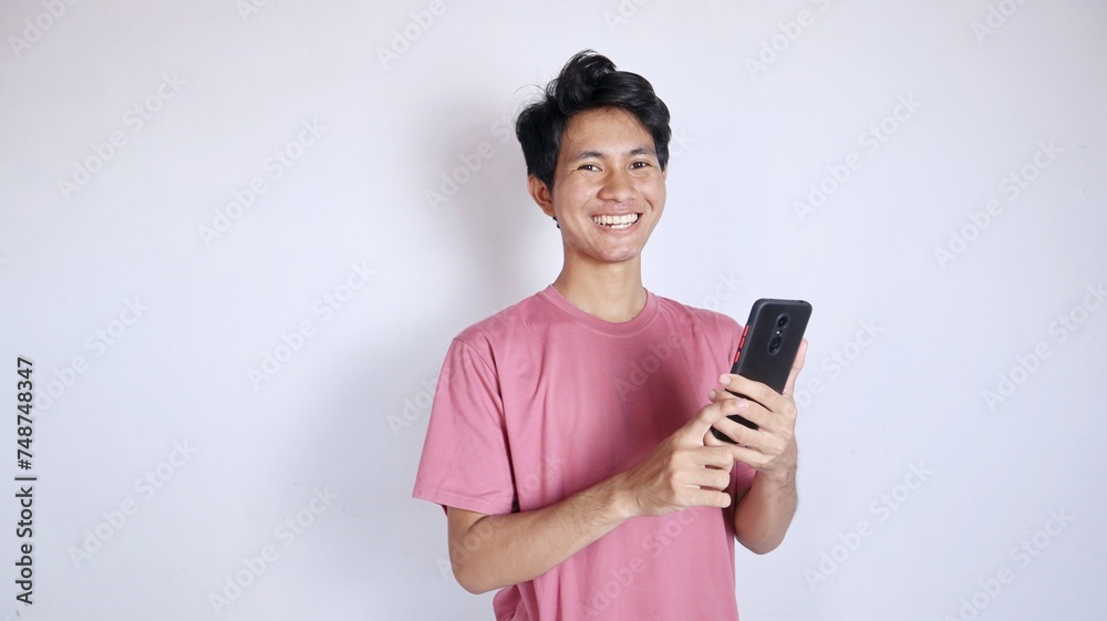 excited asian man with gesture holding smartphone excited asian man with gesture holding smartphone