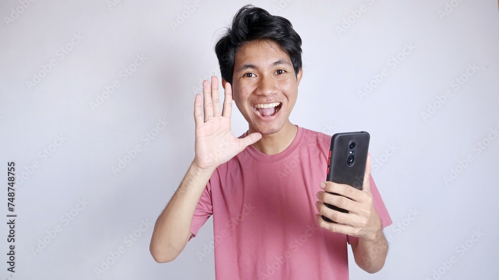 Excited Asian man with a say hi hand gesture Excited Asian man with a say hi hand gesture