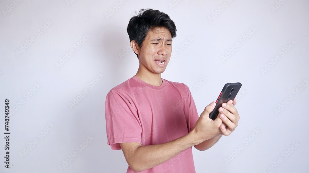sad asian man holding smartphone sad asian man holding smartphone
