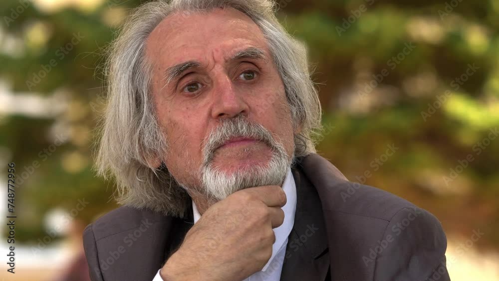thoughtful elderly man touches his beard absorbed in his reflections thoughtful elderly man touches his beard absorbed in his reflections