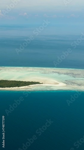 Mataking island on a coral reef or atoll with a sandy beach. Tropical landscape.Tun Sakaran Marine Park. Borneo, Sabah, Malaysia. Vertical video. photo