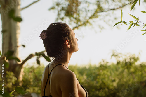 Retrato de mujer latina al sol con fondo natural, expresion relajada