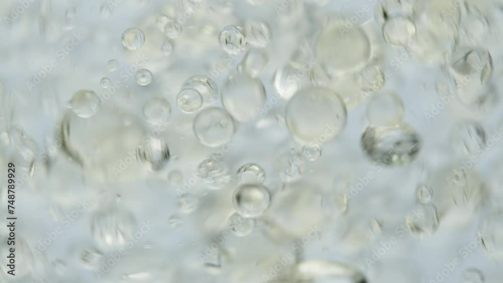 Oil bubbles in water, macro shot on a white background, slow motion. Oil bubbles in water, macro shot on a white background, slow motion.