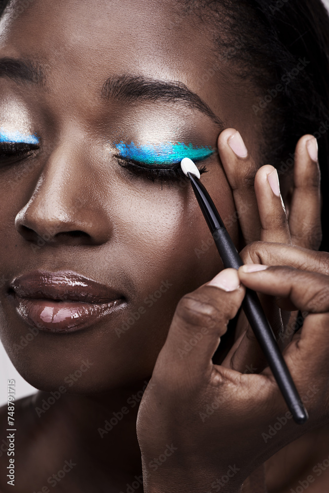 Brush, makeup and face of black woman with cosmetics for wellness, beauty and model. Cosmetology, skincare and person with tools for makeover application, blue eyeshadow and products in studio