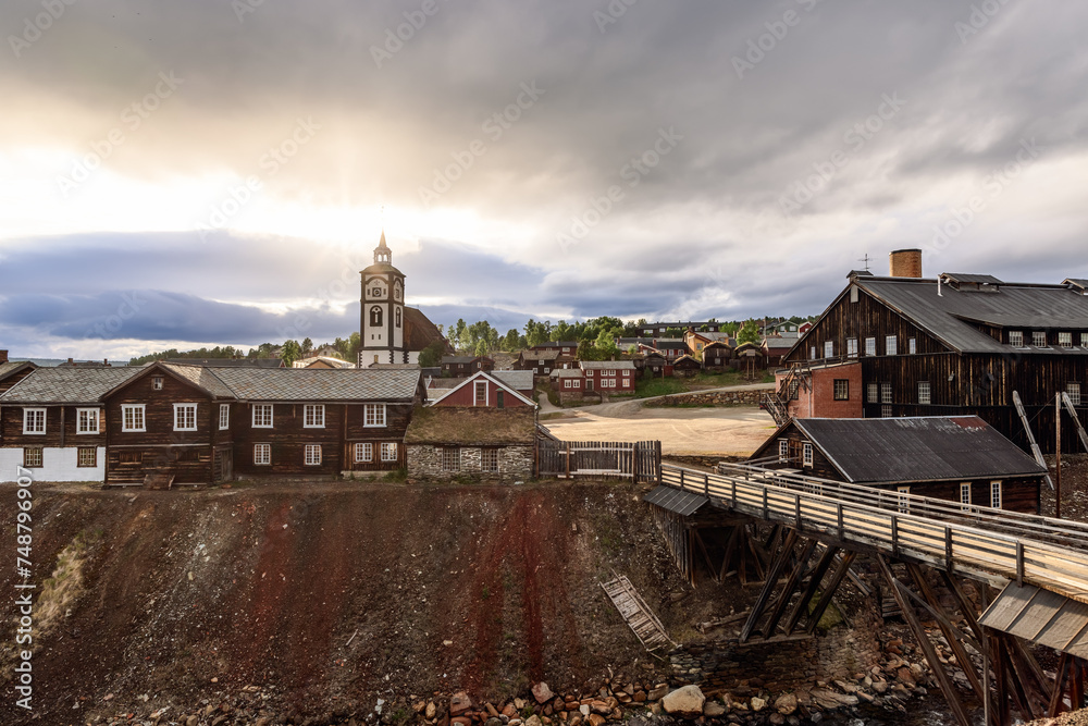 Sunset rays illuminate the charming landscape of Roros, featuring the town's landmark church and wooden architecture, a testament to its cultural legacy