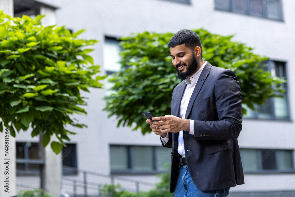 Professional businessman in a suit using a smartphone outdoors Professional businessman in a suit using a smartphone outdoors